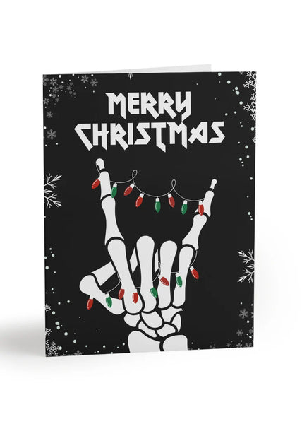 Christmas card with skeleton hand making a peace sign and 'Merry Christmas' text on a black background.
