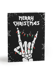 Christmas card with skeleton hand making a peace sign and 'Merry Christmas' text on a black background.